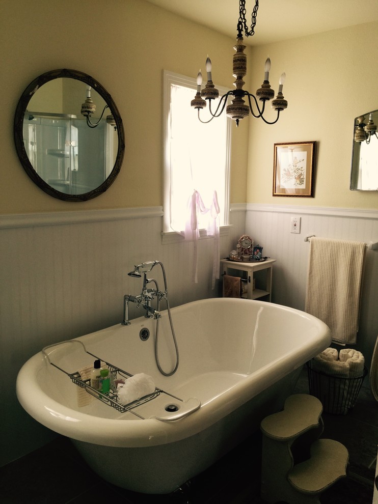 На фото: главная ванная комната среднего размера в викторианском стиле с ванной на ножках, серой плиткой, полом из керамической плитки, желтыми стенами, душем над ванной, открытым душем, раковиной с пьедесталом и бежевым полом
