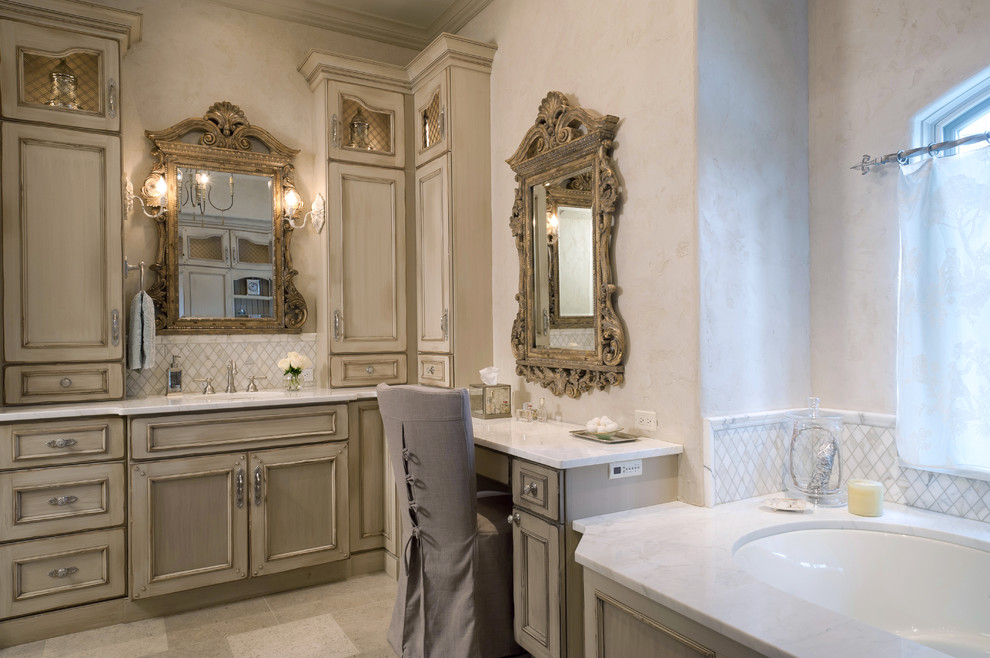 Foto di una stanza da bagno tradizionale con ante con riquadro incassato, ante con finitura invecchiata, vasca sottopiano e piastrelle bianche