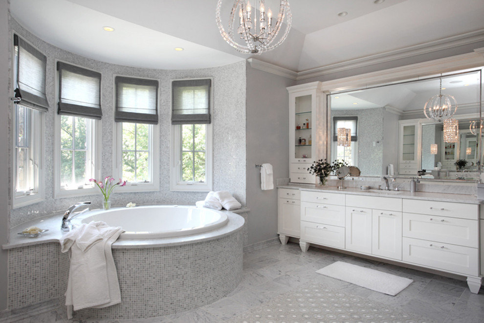 Inredning av ett klassiskt grå grått en-suite badrum, med vita skåp, marmorgolv, ett japanskt badkar, grå väggar, ett undermonterad handfat, marmorbänkskiva och grått golv