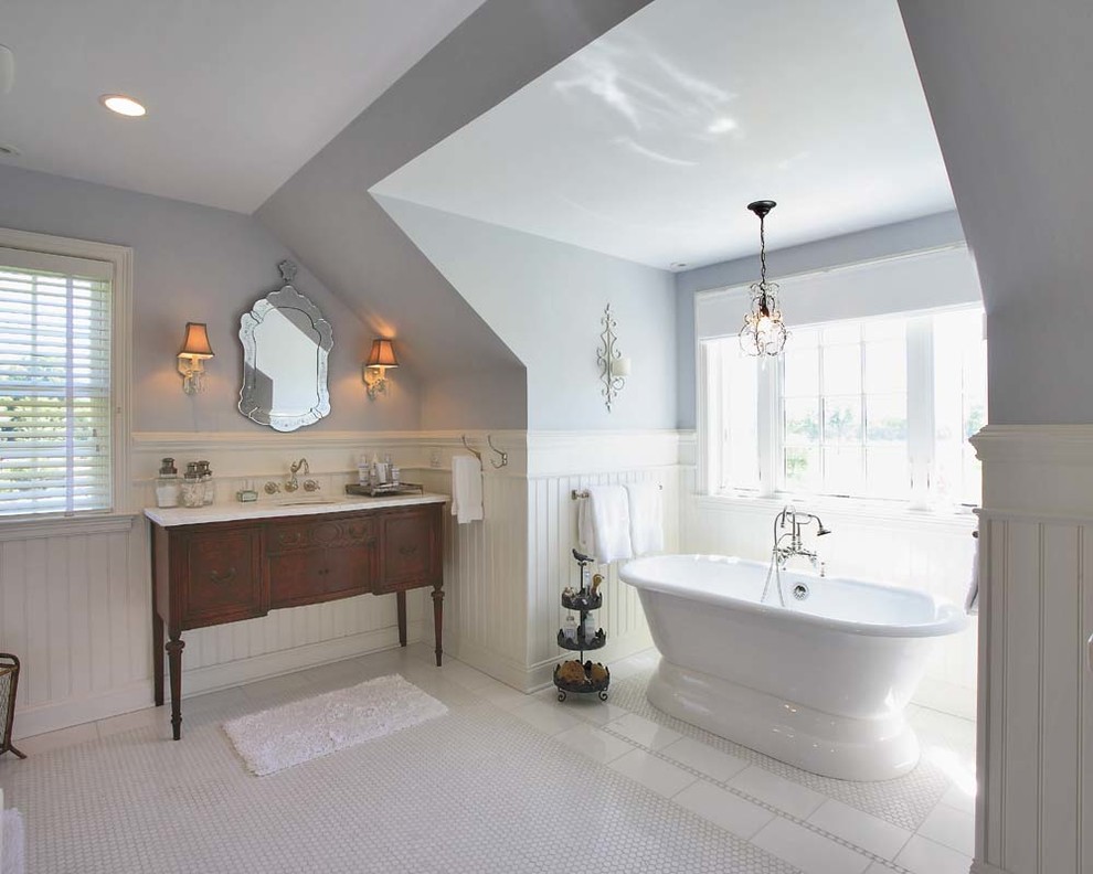 Пример оригинального дизайна: ванная комната в классическом стиле с темными деревянными фасадами, отдельно стоящей ванной, серыми стенами и фасадами с утопленной филенкой
