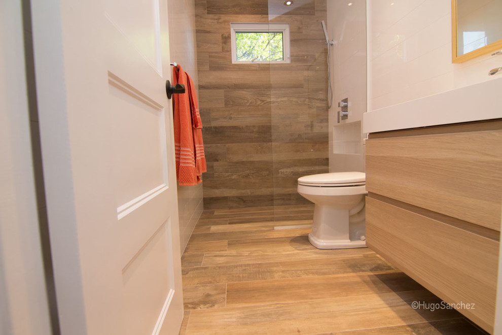 Small contemporary family bathroom in Montreal with an integrated sink, flat-panel cabinets, light wood cabinets, a built-in shower, a one-piece toilet, white walls and porcelain flooring.