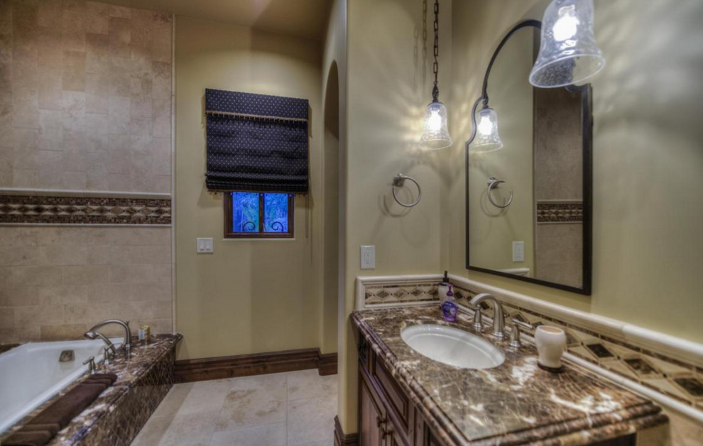 This is an example of an expansive classic ensuite bathroom in Phoenix with flat-panel cabinets, medium wood cabinets, a built-in bath, a built-in shower, a one-piece toilet, white tiles, porcelain tiles, beige walls, porcelain flooring, a built-in sink and granite worktops.