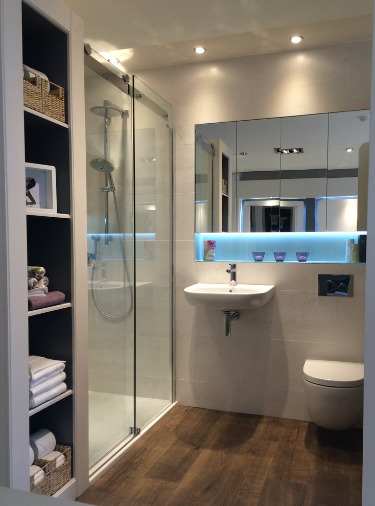 ダブリンにあるモダンスタイルのおしゃれな浴室 (壁付け型シンク、ガラスの洗面台、アルコーブ型シャワー、壁掛け式トイレ、ベージュのタイル、セラミックタイル、ベージュの壁、セラミックタイルの床) の写真