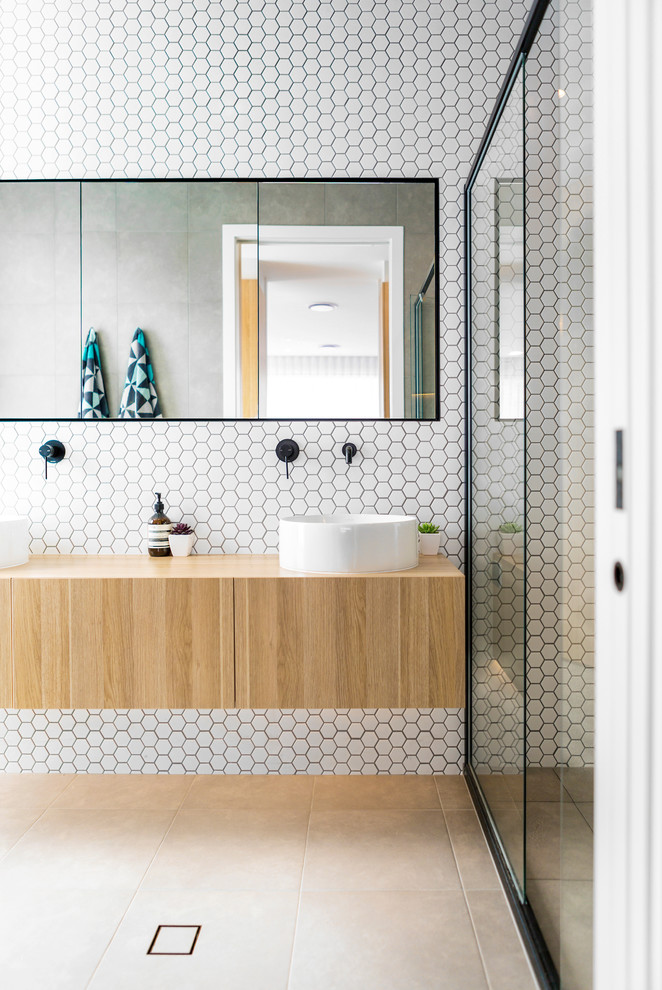Alcove shower - mid-sized contemporary master white tile and ceramic tile porcelain tile alcove shower idea in Canberra - Queanbeyan with light wood cabinets, a one-piece toilet, white walls, an integrated sink, wood countertops and a hinged shower door