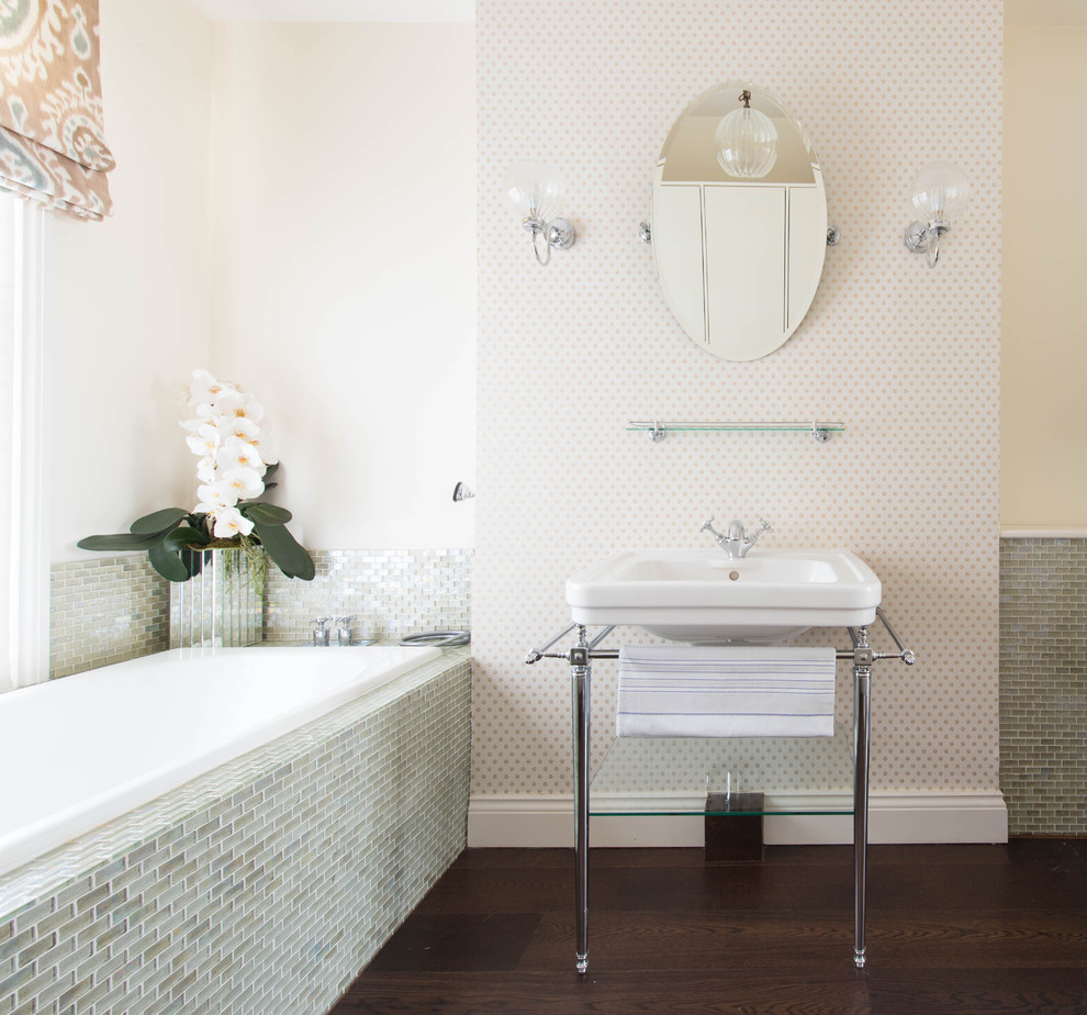 Photo of a traditional ensuite bathroom in London with grey tiles, beige walls, dark hardwood flooring, a console sink, brown floors, a built-in bath and mosaic tiles.