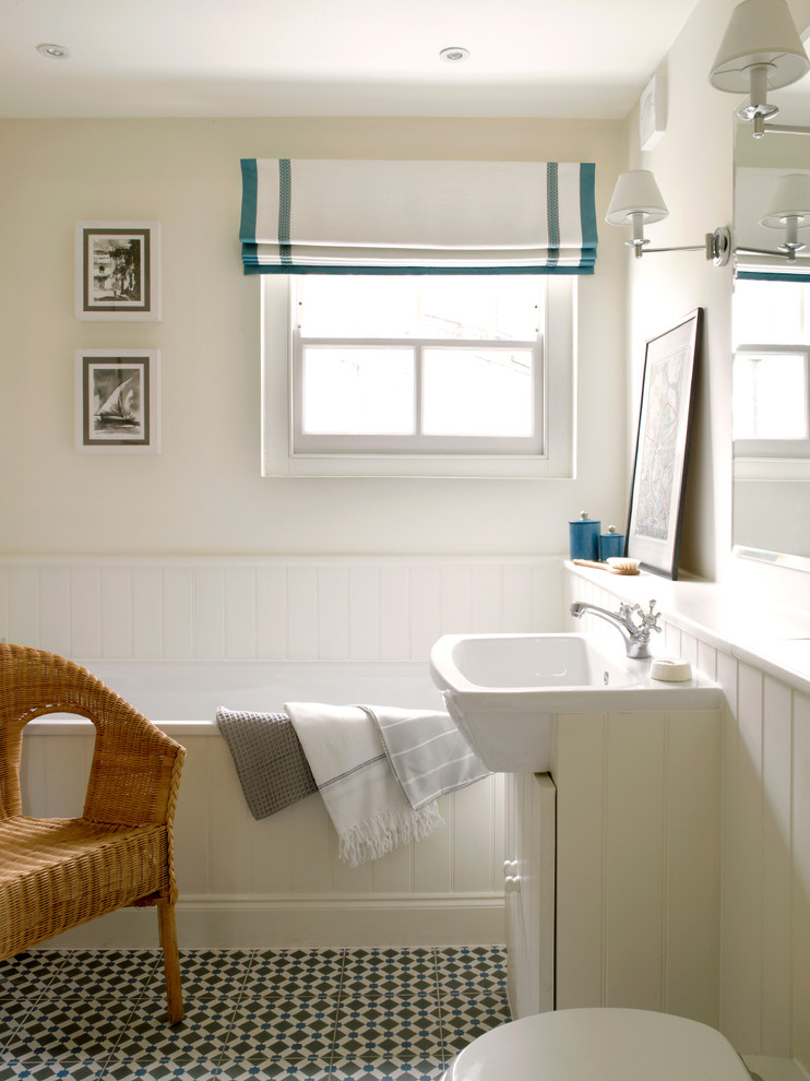Diseño de cuarto de baño actual con lavabo encastrado, puertas de armario blancas, bañera encastrada y suelo multicolor