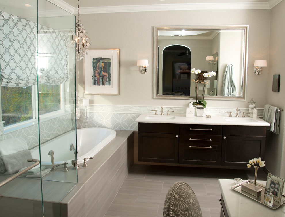 Diseño de cuarto de baño clásico renovado con lavabo bajoencimera, armarios estilo shaker, puertas de armario de madera en tonos medios, bañera encastrada, baldosas y/o azulejos grises y ventanas
