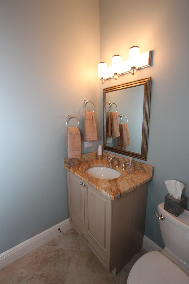 Inspiration for a small timeless beige tile and porcelain tile porcelain tile bathroom remodel in Miami with an undermount sink, raised-panel cabinets, light wood cabinets, granite countertops, a two-piece toilet and blue walls