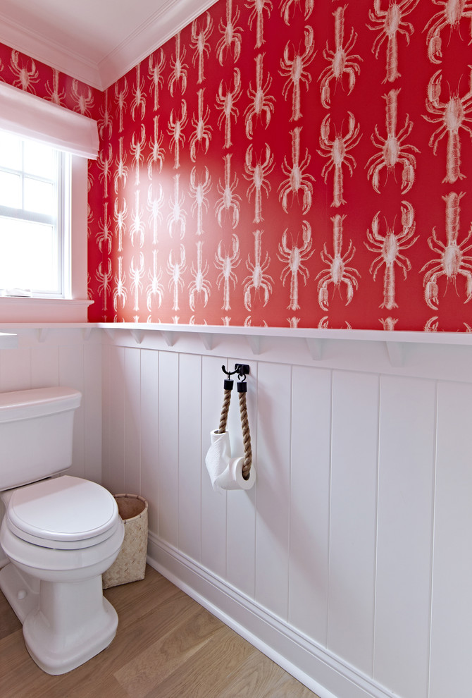Idéer för stora maritima badrum för barn, med en toalettstol med separat cisternkåpa, röda väggar, ljust trägolv, ett undermonterad handfat och marmorbänkskiva