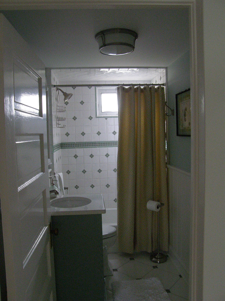 Ispirazione per una piccola stanza da bagno classica con vasca ad alcova, vasca/doccia, pareti blu, ante verdi, WC monopezzo, piastrelle bianche, piastrelle in ceramica, pavimento con piastrelle in ceramica e lavabo integrato