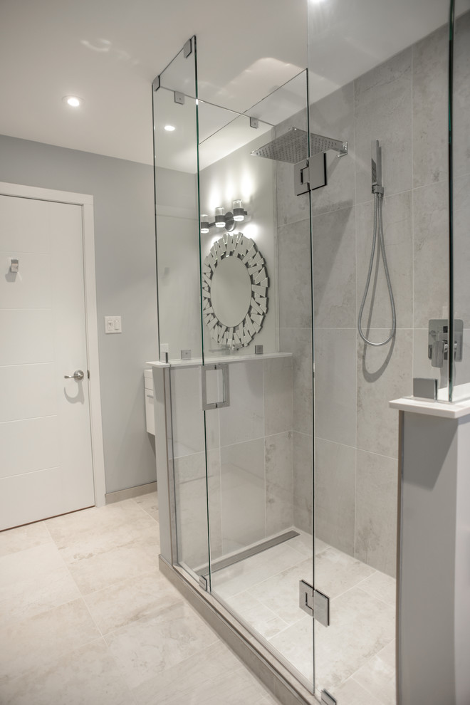 Medium sized contemporary ensuite bathroom in Toronto with white cabinets, a one-piece toilet, grey tiles, porcelain tiles, grey walls, porcelain flooring, a wall-mounted sink and solid surface worktops.