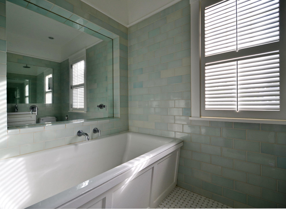 Diseño de cuarto de baño actual con puertas de armario blancas, bañera exenta, baldosas y/o azulejos azules, paredes azules y suelo blanco
