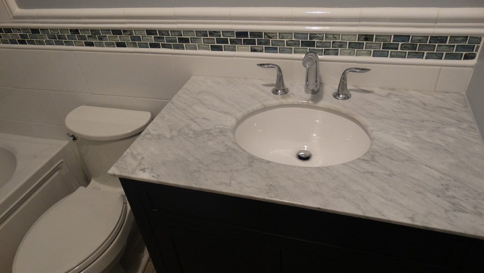 Small trendy 3/4 multicolored tile light wood floor bathroom photo in Cleveland with an undermount sink, recessed-panel cabinets, dark wood cabinets, marble countertops and gray walls