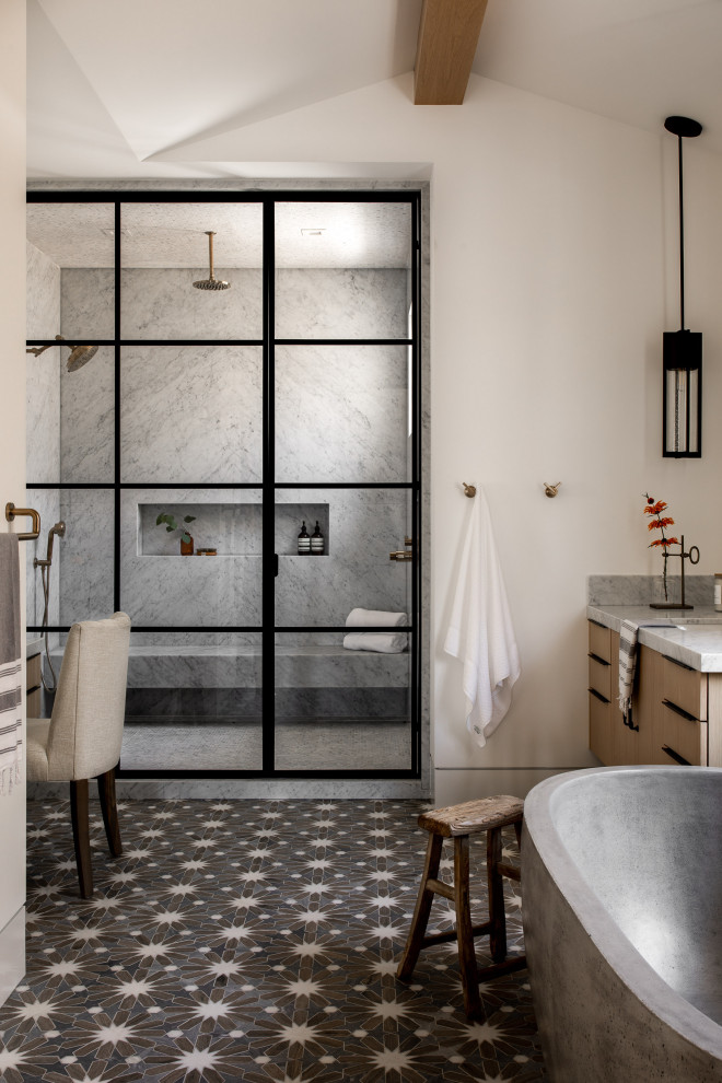 Cette image montre une salle de bain rustique en bois brun avec un placard à porte plane, une baignoire indépendante, un mur blanc, un lavabo encastré, un sol noir, un plan de toilette gris, une niche, un banc de douche, meuble-lavabo suspendu et un plafond voûté.