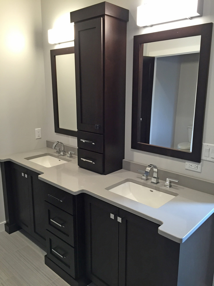 Ejemplo de cuarto de baño urbano de tamaño medio con armarios con paneles empotrados, puertas de armario negras y lavabo integrado