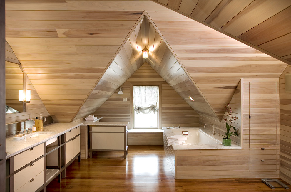 Modernes Badezimmer En Suite in Dachschräge mit Unterbauwaschbecken, flächenbündigen Schrankfronten, hellen Holzschränken, Unterbauwanne und braunem Holzboden in Austin