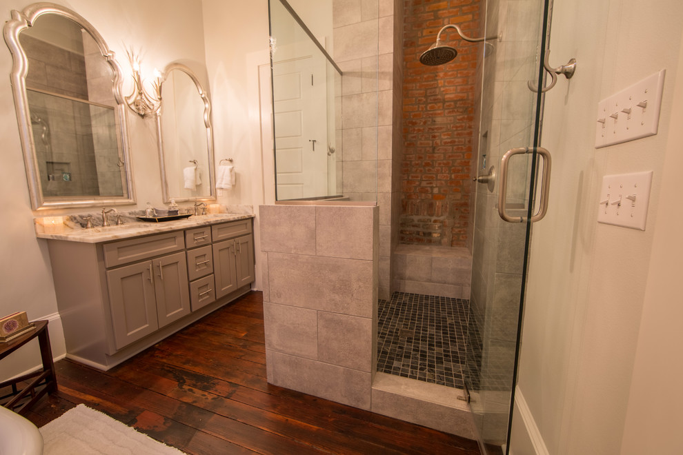Example of a mid-sized transitional master dark wood floor alcove shower design in New Orleans with shaker cabinets, gray cabinets, a two-piece toilet, white walls, an undermount sink and quartz countertops