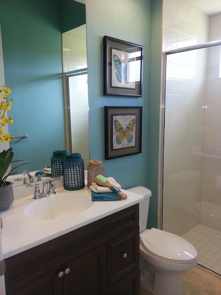 Inspiration for a mid-sized coastal 3/4 multicolored tile and ceramic tile travertine floor alcove shower remodel in Orlando with an integrated sink, raised-panel cabinets, dark wood cabinets, granite countertops, a one-piece toilet and blue walls