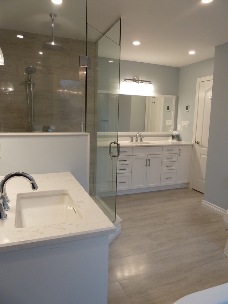 This is an example of a large traditional ensuite bathroom in Toronto with shaker cabinets, white cabinets, a freestanding bath, a corner shower, grey walls, light hardwood flooring, a submerged sink, engineered stone worktops, beige floors and a hinged door.