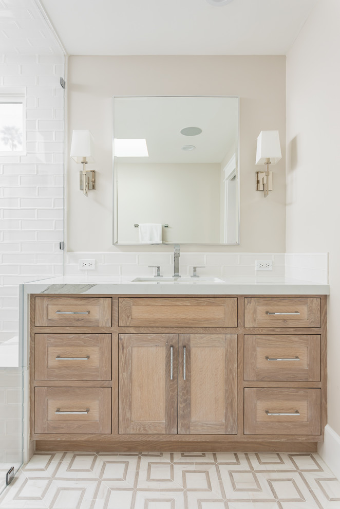 Cette image montre une salle de bain traditionnelle en bois brun avec un placard à porte shaker, une douche à l'italienne, un carrelage blanc, un carrelage métro, un mur blanc, un lavabo encastré, un plan de toilette en bois et un sol multicolore.