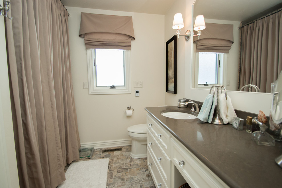 Foto di una stanza da bagno padronale tradizionale di medie dimensioni con lavabo integrato, ante con riquadro incassato, ante bianche, vasca/doccia e pareti bianche