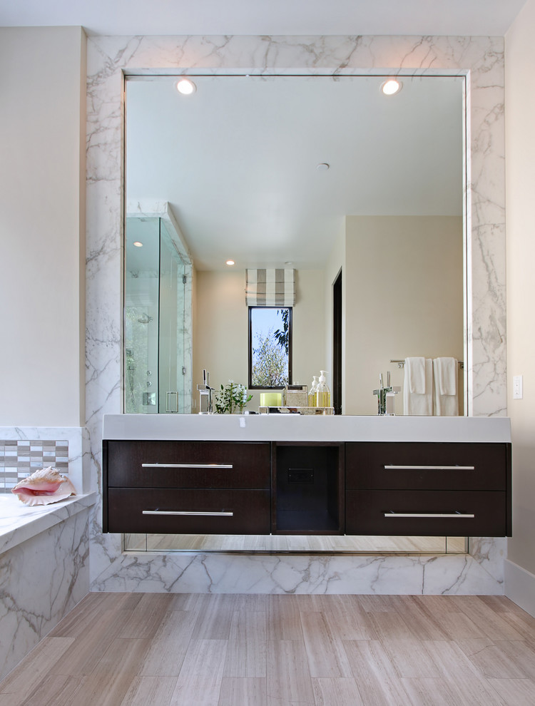 Ejemplo de cuarto de baño actual con armarios con paneles lisos, puertas de armario de madera en tonos medios, baldosas y/o azulejos blancos y baldosas y/o azulejos de mármol