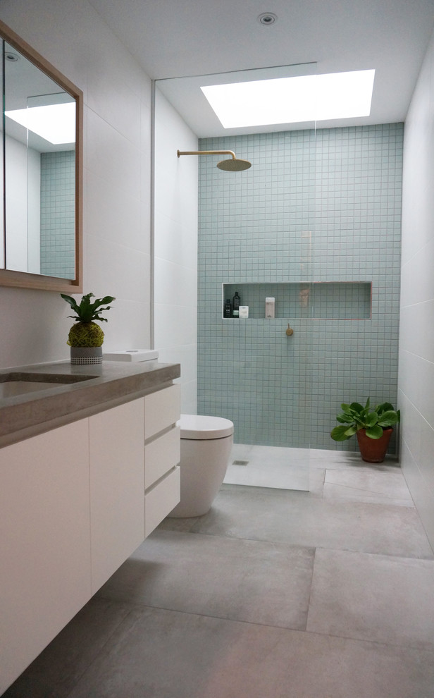 Idee per una stanza da bagno padronale design con ante bianche, pareti bianche, lavabo sottopiano, top in cemento, doccia ad angolo, WC a due pezzi, piastrelle blu, piastrelle bianche e doccia aperta