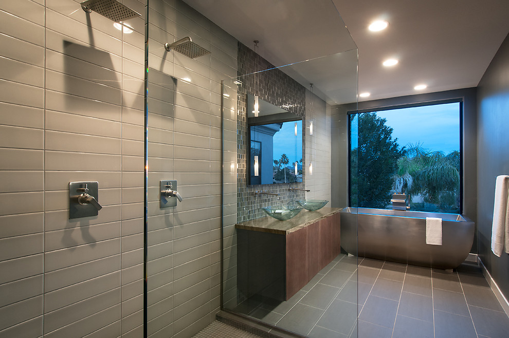 This is an example of a large contemporary ensuite bathroom in Phoenix with a vessel sink, flat-panel cabinets, dark wood cabinets, quartz worktops, a freestanding bath, a walk-in shower, grey tiles, porcelain tiles, grey walls and slate flooring.