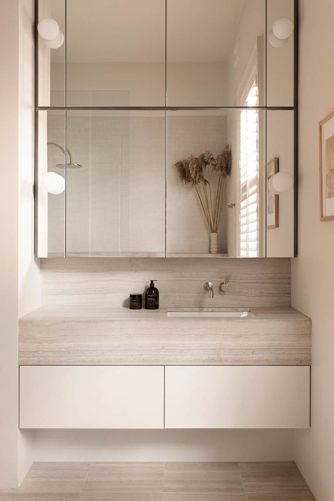 Mittelgroßes Modernes Badezimmer En Suite mit flächenbündigen Schrankfronten, weißen Schränken, weißer Wandfarbe, Unterbauwaschbecken, grauem Boden und grauer Waschtischplatte in Melbourne