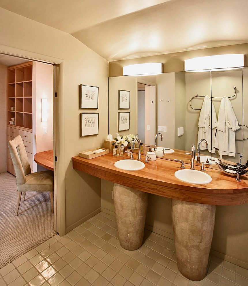 Exemple d'une salle de bain tendance avec un lavabo encastré et un plan de toilette en bois.