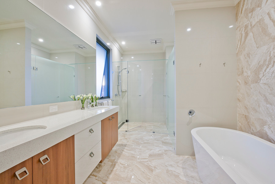 Inspiration for a medium sized contemporary ensuite bathroom in Perth with a submerged sink, beige cabinets, solid surface worktops, a freestanding bath, an alcove shower, a wall mounted toilet, black tiles, stone tiles, black walls and mosaic tile flooring.