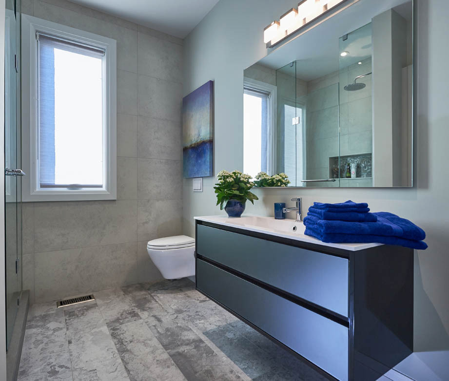 Idéer för ett mellanstort modernt vit badrum, med släta luckor, grå skåp, en vägghängd toalettstol, grå kakel, cementkakel, grå väggar, betonggolv, ett integrerad handfat, laminatbänkskiva och grått golv
