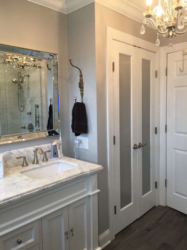 Foto de cuarto de baño costero de tamaño medio con armarios estilo shaker, puertas de armario blancas, sanitario de dos piezas, paredes grises, suelo vinílico, aseo y ducha y lavabo bajoencimera