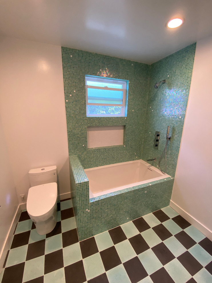 Idées déco pour une salle de bain principale exotique de taille moyenne avec un placard à porte plane, des portes de placard marrons, une baignoire encastrée, un combiné douche/baignoire, WC séparés, un carrelage vert, mosaïque, un mur beige, un sol en carrelage de porcelaine, un lavabo encastré, un plan de toilette en surface solide, un sol multicolore, une cabine de douche à porte battante, un plan de toilette blanc, meuble double vasque et meuble-lavabo suspendu.
