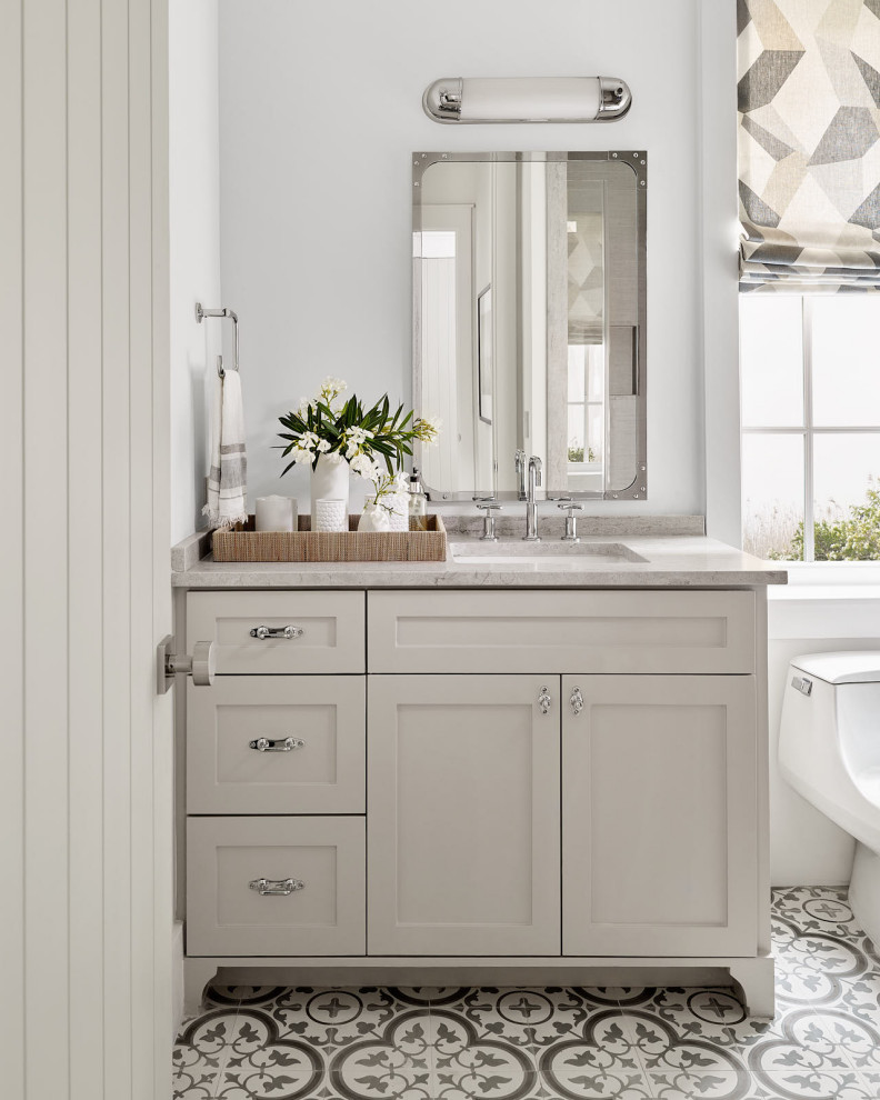 Inspiration for a small coastal 3/4 white tile ceramic tile, gray floor and double-sink bathroom remodel in Houston with recessed-panel cabinets, white cabinets, a one-piece toilet, white walls, a drop-in sink, a hinged shower door, gray countertops and a built-in vanity