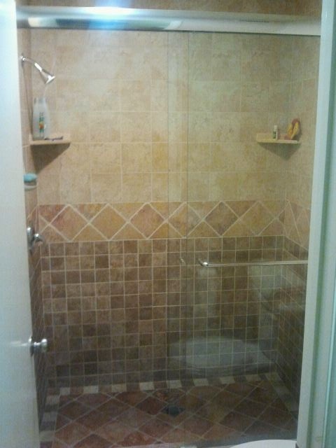 Diseño de cuarto de baño costero de tamaño medio con ducha empotrada, baldosas y/o azulejos beige, baldosas y/o azulejos marrones, baldosas y/o azulejos de cerámica y aseo y ducha