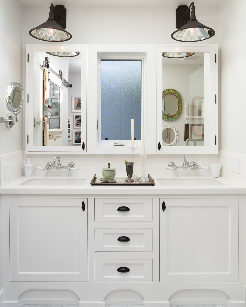 Imagen de cuarto de baño principal costero con paredes blancas, ducha con puerta con bisagras y encimeras blancas