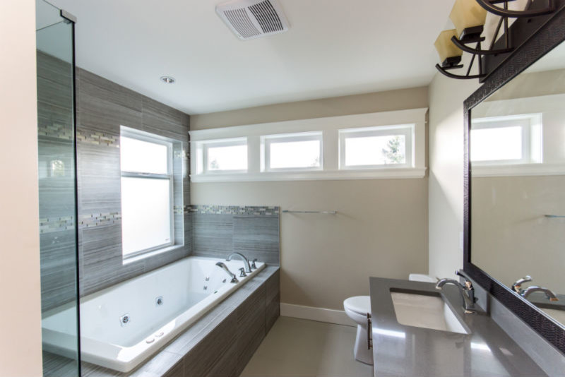 Idéer för ett mellanstort modernt badrum med dusch, med grå kakel, porslinskakel, ett hörnbadkar, en hörndusch, en toalettstol med hel cisternkåpa, beige väggar, linoleumgolv, ett undermonterad handfat och bänkskiva i akrylsten
