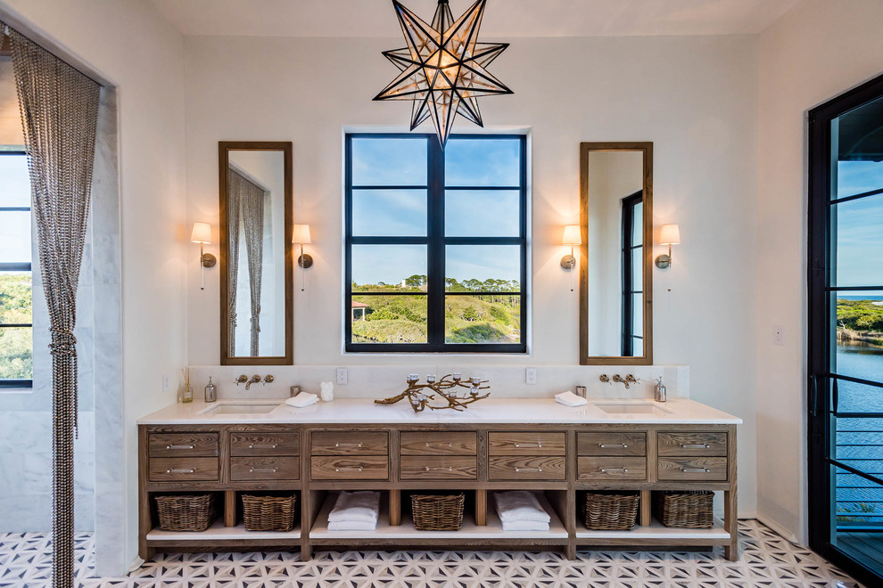 Cette image montre une salle de bain méditerranéenne en bois foncé avec une douche ouverte, un mur blanc, un lavabo encastré, un sol multicolore, carreaux de ciment au sol, un plan de toilette en surface solide, un plan de toilette blanc et un placard à porte affleurante.