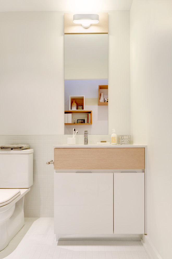 Kleines Modernes Duschbad mit integriertem Waschbecken, flächenbündigen Schrankfronten, weißen Schränken, Mineralwerkstoff-Waschtisch, Wandtoilette mit Spülkasten, weißen Fliesen, Porzellanfliesen, weißer Wandfarbe und Porzellan-Bodenfliesen in Toronto
