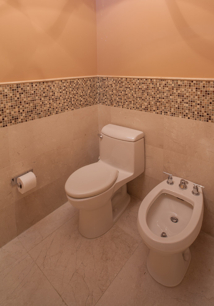 他の地域にある高級な中くらいなコンテンポラリースタイルのおしゃれなトイレ・洗面所 (一体型トイレ	、フラットパネル扉のキャビネット、中間色木目調キャビネット、大理石の洗面台、マルチカラーのタイル、モザイクタイル、アンダーカウンター洗面器、オレンジの壁、大理石の床) の写真