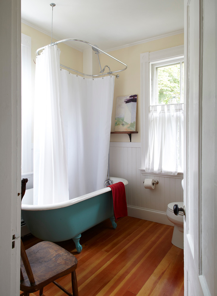 Beach style claw-foot bathtub photo in San Francisco with yellow walls