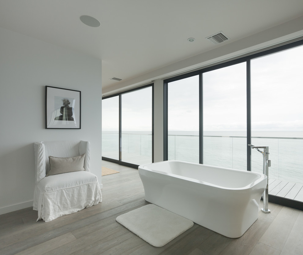 Стильный дизайн: большая главная ванная комната в современном стиле с отдельно стоящей ванной, белыми стенами, светлым паркетным полом и белой плиткой - последний тренд