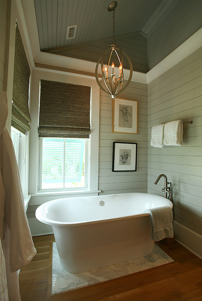 Example of a mid-sized island style 3/4 medium tone wood floor drop-in bathtub design in Atlanta with green walls