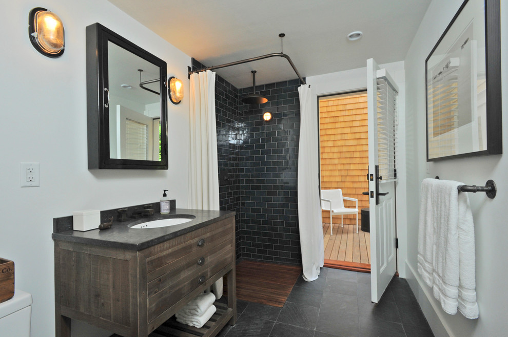 Inspiration for a medium sized contemporary shower room bathroom in London with freestanding cabinets, dark wood cabinets, a corner shower, a one-piece toilet, black tiles, stone tiles, white walls, slate flooring, a submerged sink and granite worktops.