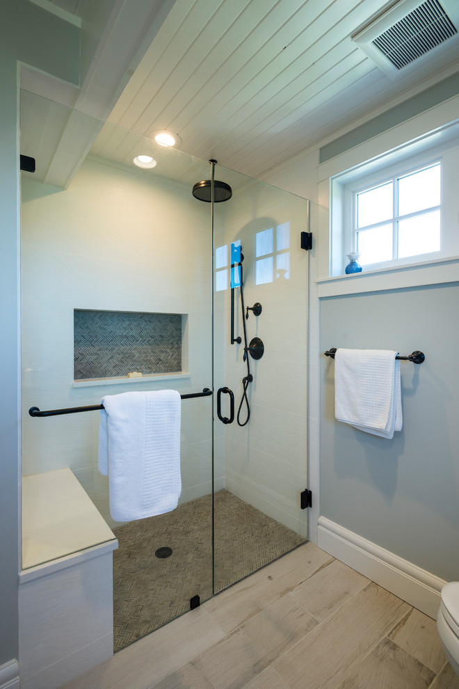Cette photo montre une petite salle de bain bord de mer avec WC séparés, un mur gris, un sol en carrelage de porcelaine, un lavabo encastré, un sol beige et une cabine de douche à porte battante.