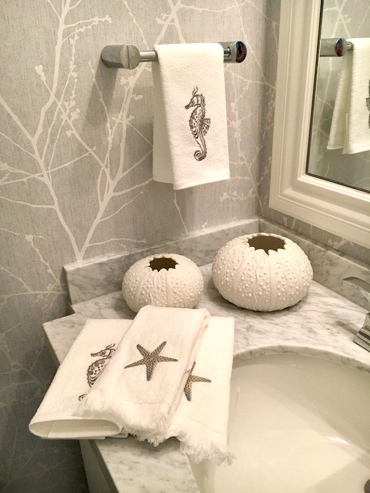 Diseño de cuarto de baño costero pequeño con armarios estilo shaker, puertas de armario blancas, paredes grises, suelo laminado, lavabo bajoencimera, encimera de mármol y suelo gris