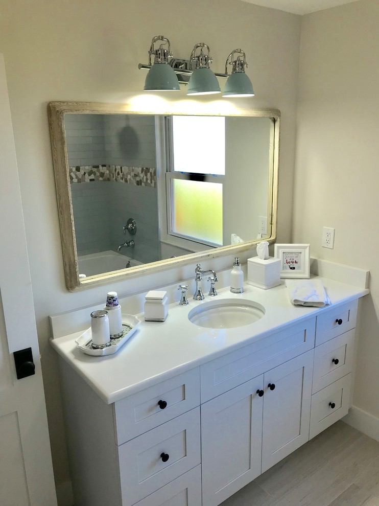 Example of a mid-sized beach style 3/4 multicolored tile and ceramic tile ceramic tile and gray floor bathroom design in Miami with shaker cabinets, white cabinets, beige walls and an undermount sink