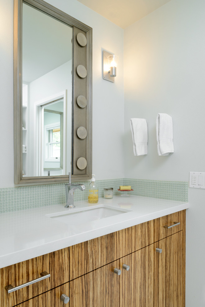 シアトルにあるビーチスタイルのおしゃれな浴室 (アンダーカウンター洗面器、フラットパネル扉のキャビネット、中間色木目調キャビネット、緑のタイル、ガラスタイル、白い壁) の写真