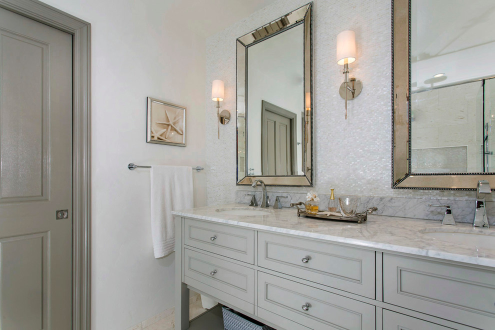 На фото: главная ванная комната среднего размера в стиле неоклассика (современная классика) с фасадами с утопленной филенкой, серыми фасадами, душем без бортиков, белой плиткой, плиткой из листового стекла, серыми стенами, полом из известняка, врезной раковиной, мраморной столешницей, бежевым полом и открытым душем с